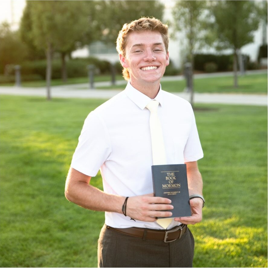 Elder Archibald holding the Book of Mormon
